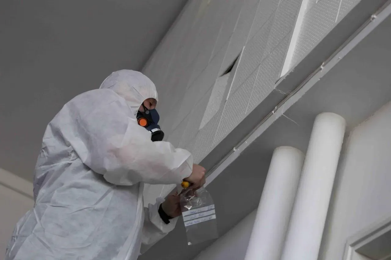 Asbestos surveyor taking a sample from a ceiling